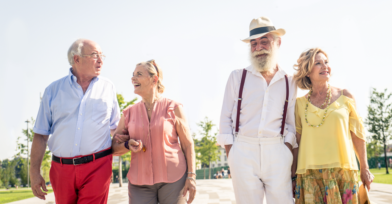 Two elderly couples walking down the park