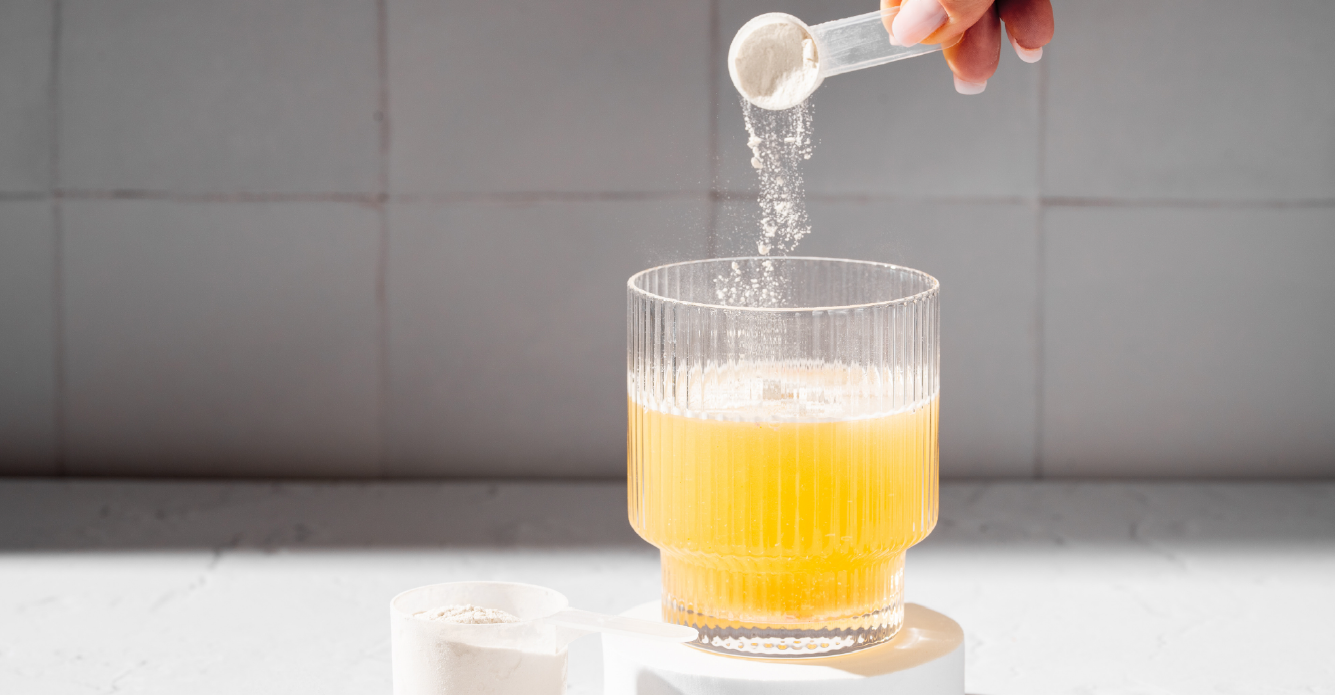 collagen powder being added to orange juice 