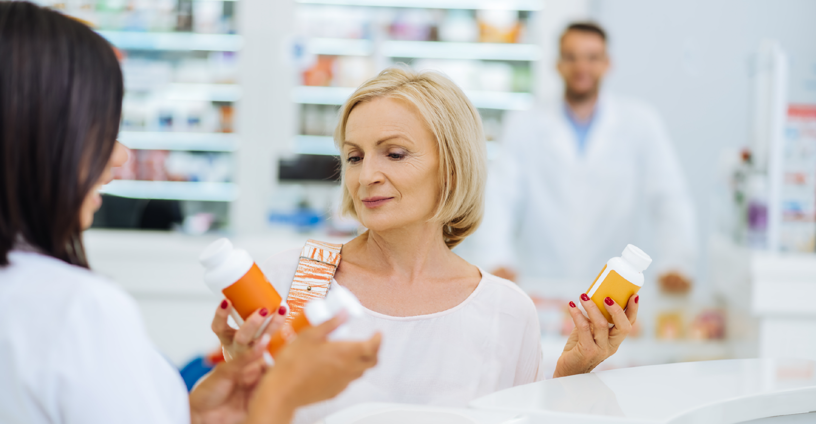 woman reading the label of various vitamins 